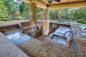 outdoor kitchen with sink, grill, sideburner, refrigerator, trash slide