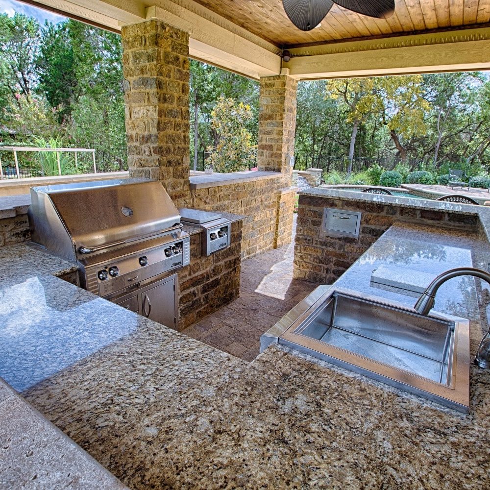 outdoor kitchen with sink, grill, sideburner, refrigerator, trash slide